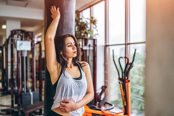 Wanita Lelah Dalam Pakaian Olahraga Bersandar Pada Karung Tinju Gym — Stok Foto