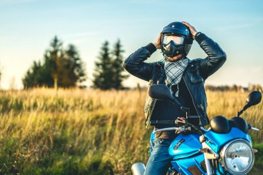 Kask spor motosiklet yolda açık otururken başının üstüne koyarak motorcu