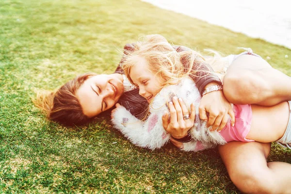 Madre Con Hija Pequeña Divirtiéndose Abrazándose Mientras Está Acostada Hierba — Foto de Stock