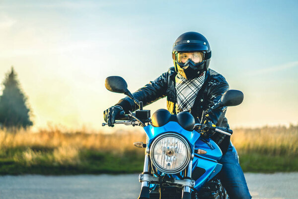 Biker riding on sport motorcycle outdoor on road