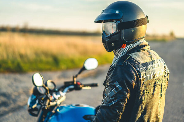 side view of biker wearing helmet sitting on sport motorcycle outdoor 