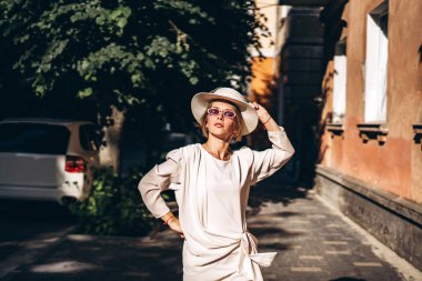 Sokakta yürürken beyaz vintage elbiseli güzel kadın