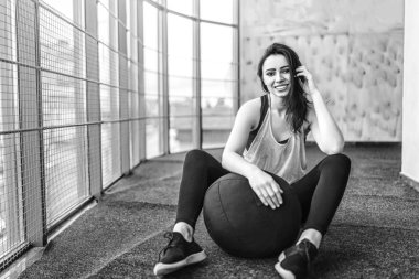 Oldukça sportif kadın spor salonunda oturan tek renkli fotoğrafı