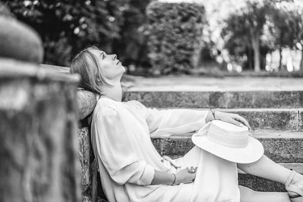 屋外の階段に座っている白いビンテージ ドレスのきれいな女性の白黒ビュー — ストック写真