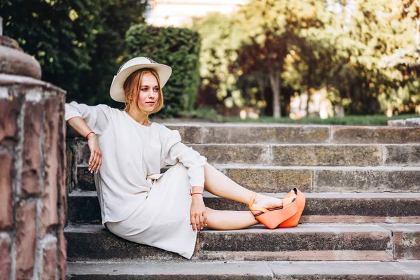 屋外の階段に座っている白いビンテージ ドレスのきれいな女性 — ストック写真