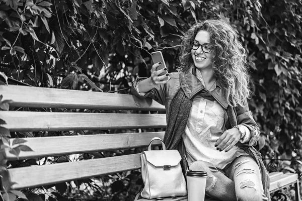 Chica Bonita Con Pelo Rizado Beber Café Uso Teléfono Inteligente — Foto de Stock
