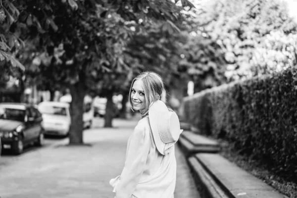 白いヴィンテージのドレスと帽子の通りの上を歩く若い女性 — ストック写真