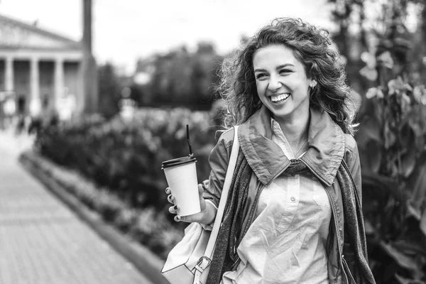 Meisje Met Krullend Haar Bedrijf Koffiekopje Lachend Straat Zwart Wit — Stockfoto