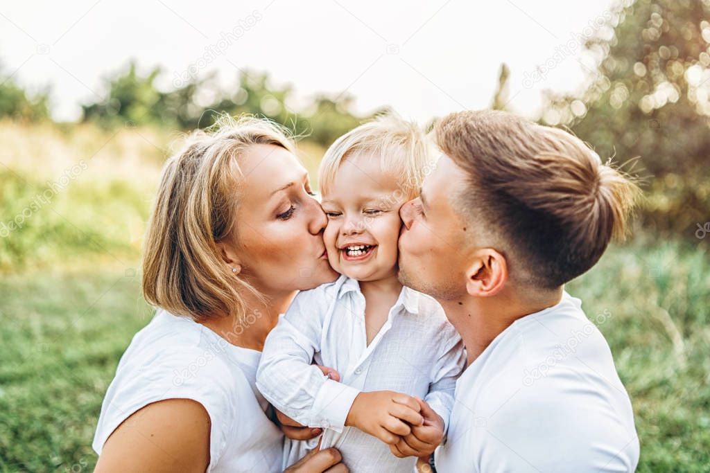 Young pretty family with little son having  fun outdoors