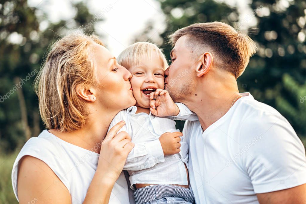 Young pretty family with little son having  fun outdoors