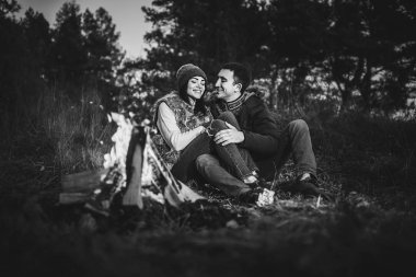 Oldukça genç çift rahatlatıcı zaman akşam, ormandaki şenlik ateşi yakın