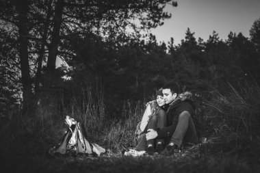 Oldukça genç çift rahatlatıcı zaman akşam, ormandaki şenlik ateşi yakın