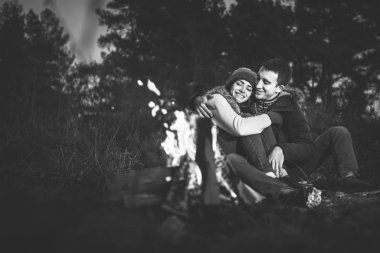 Oldukça genç çift rahatlatıcı zaman akşam, ormandaki şenlik ateşi yakın