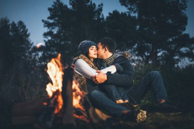 Oldukça genç çift rahatlatıcı zaman akşam, ormandaki şenlik ateşi yakın