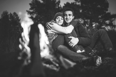 Oldukça genç çift rahatlatıcı zaman akşam, ormandaki şenlik ateşi yakın