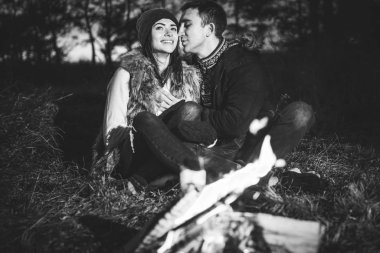 Oldukça genç çift rahatlatıcı zaman akşam, ormandaki şenlik ateşi yakın