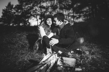 Oldukça genç çift rahatlatıcı zaman akşam, ormandaki şenlik ateşi yakın