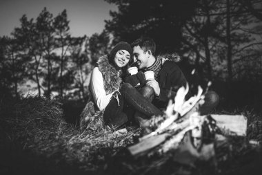 Şenlik ateşi yakınındaki ormanda sıcak içecek içme oldukça genç çift