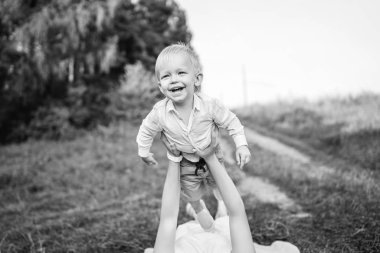 Genç Anne ile küçük oğlu örtüm çayır, yatarken eğleniyor 