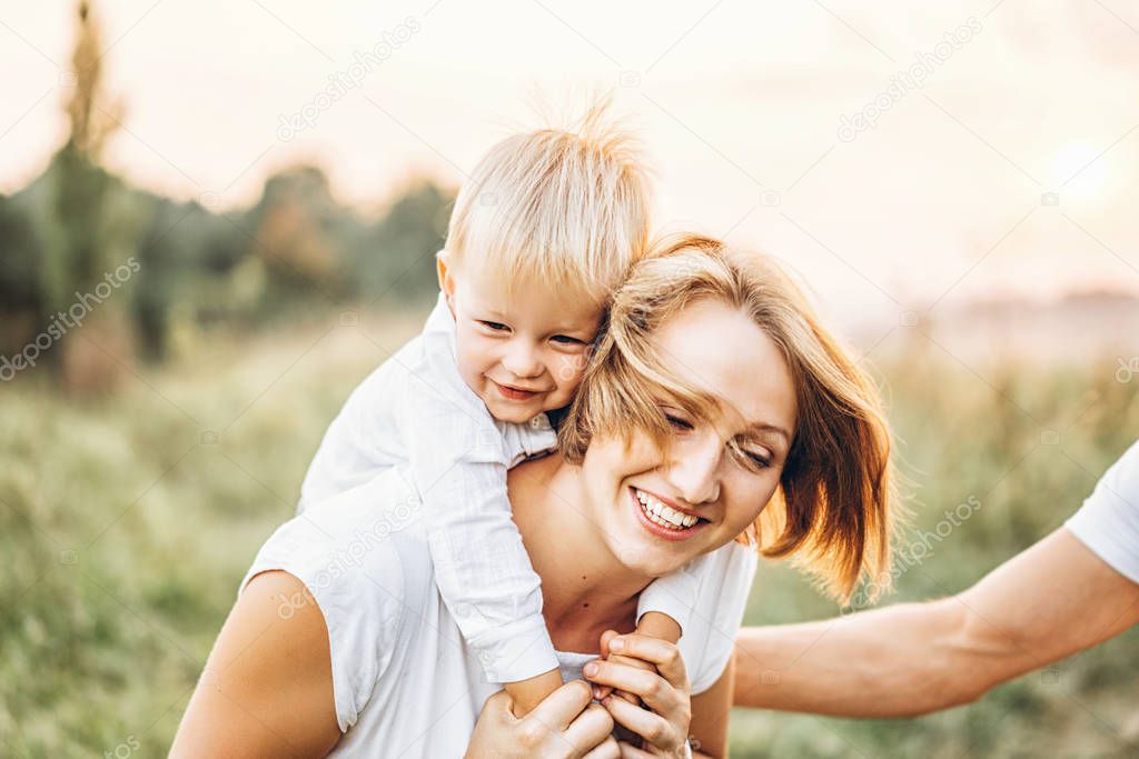 smiling mother giving son piggyback ride outdoor