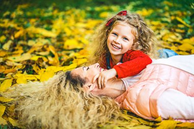 Anne küçük kızı düşen sonbahar yaprakları park yatan süre having fun ile