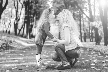 Küçük kızı birbirlerine sonbahar parkında eğlenirken öpüşme ile anne