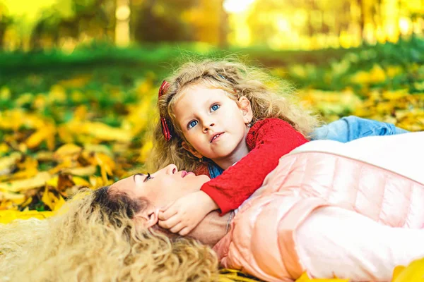 Matka Córką Trochę Zabawy Leżąc Opadłych Liści Jesienią Parku — Zdjęcie stockowe