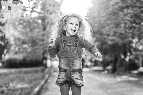 美丽的小女孩卷曲的发型穿着休闲服装在秋季公园的乐趣 — 图库照片