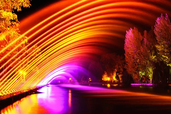 長時間露光の都市公園における明るいカラフルな噴水 — ストック写真