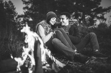 Oldukça genç çift rahatlatıcı zaman akşam, ormandaki şenlik ateşi yakın