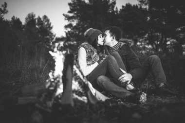 Oldukça genç çift rahatlatıcı zaman akşam, ormandaki şenlik ateşi yakın