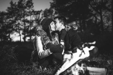 Oldukça genç çift rahatlatıcı zaman akşam, ormandaki şenlik ateşi yakın