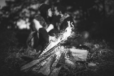 Oldukça genç çift rahatlatıcı zaman akşam, ormandaki şenlik ateşi yakın