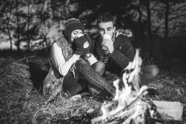 Şenlik ateşi yakınındaki ormanda sıcak içecek içme oldukça genç çift