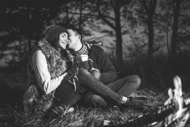 Şenlik ateşi yakınındaki ormanda sıcak içecek içme oldukça genç çift