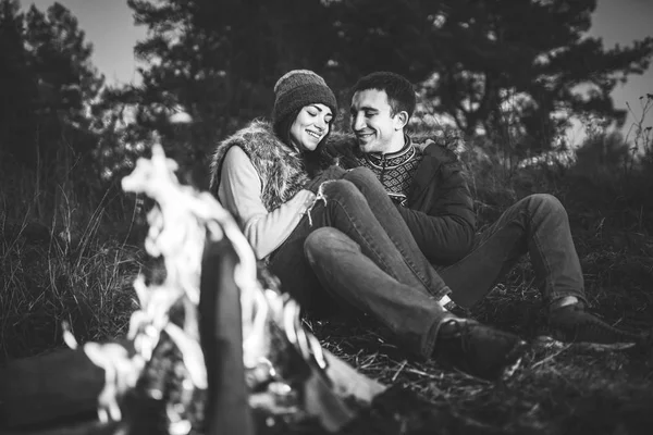 美丽的年轻夫妇放松附近的森林篝火在晚上的时间 — 图库照片