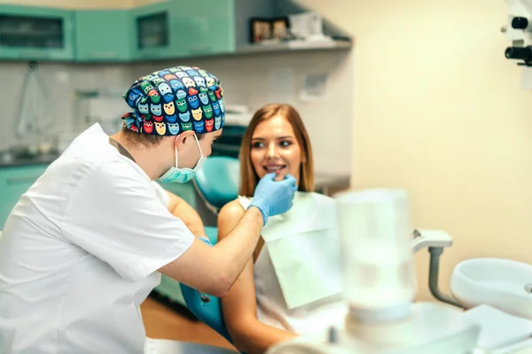 歯科医は Denal オフィスでブレースを有する女性患者を診察します — ストック写真