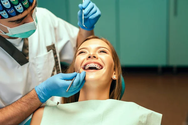 Dentista Examina Paciente Feminina Com Aparelho Consultório Denal — Fotografia de Stock