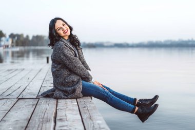 Oldukça uzun saçlı esmer kız rahatlatıcı iskeleye yakın göl