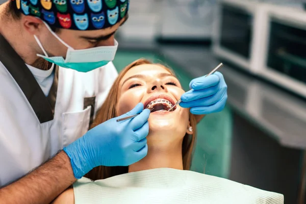 Dentista Examina Paciente Feminina Com Aparelho Consultório Denal — Fotografia de Stock