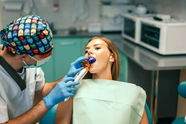 歯科医院の中かっこを持つ少女の治療を実施歯科医 — ストック写真