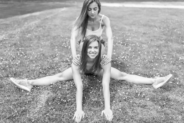 Two Pretty Sporty Girls Doing Stretching Exersises Outdoor — Stock Photo, Image