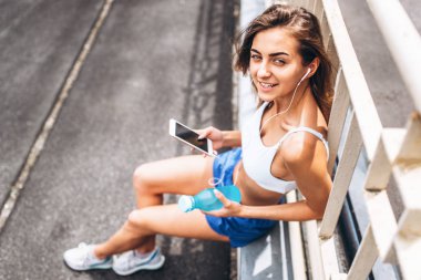 Oldukça sportif kız rahatlatıcı sonra eğitim ve dinleme müzik telefon