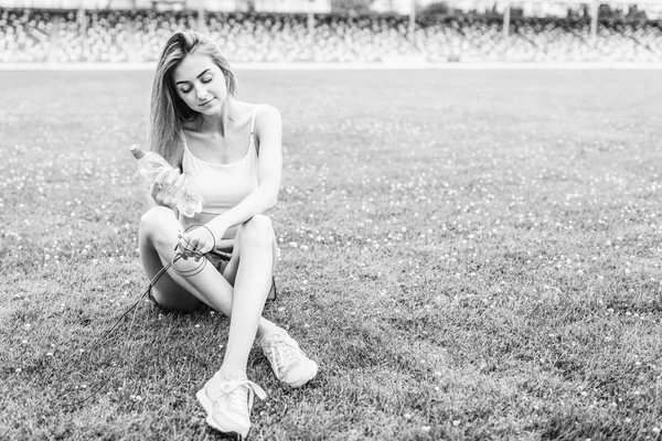 Красивая Спортивная Девушка Отдыхающая Траве После Тренировки Свежем Воздухе Бутылкой — стоковое фото