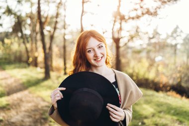 Güzel ve mutlu kızıl saçlı kız ormanda yürüyüş