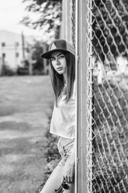 Metal ızgara Bahçesi üzerinde yakınındaki oldukça sportif esmer kız