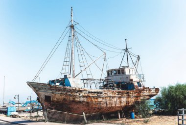 Kara deniz kenarında duran eski paslı balıkçı gemisi