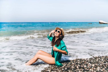 Güzel pan Asya seyahat kız rahatlatıcı yeşil pareo denizde plaj