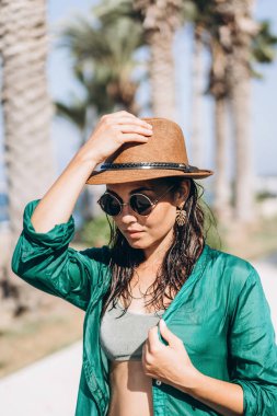 Şapka ve güneş gözlüğü yeşil pareo deniz yürüyüş içinde şirin tava Asyalı kız