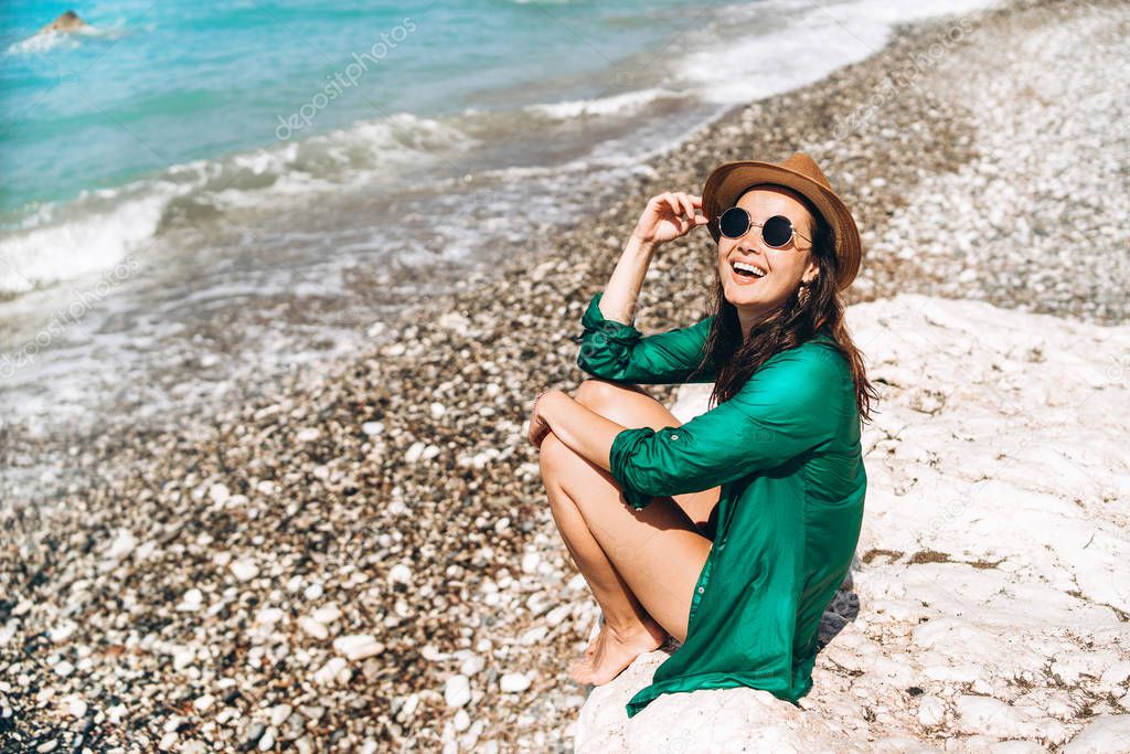 Pretty pan asian travel girl relaxing on the beach at the sea in green pareo